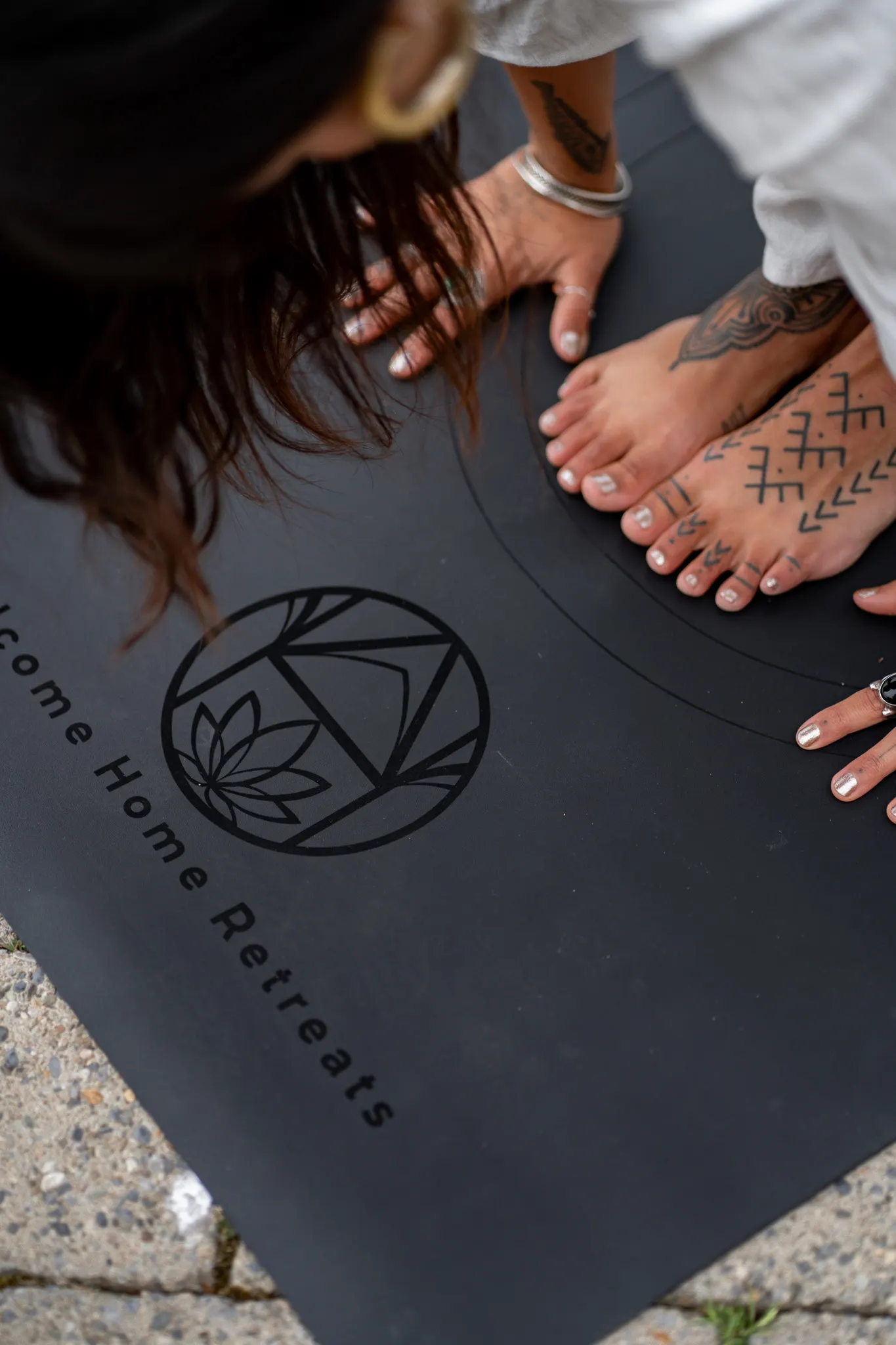 Bare feet gathered around a Welcome Home Retreats yoga mat