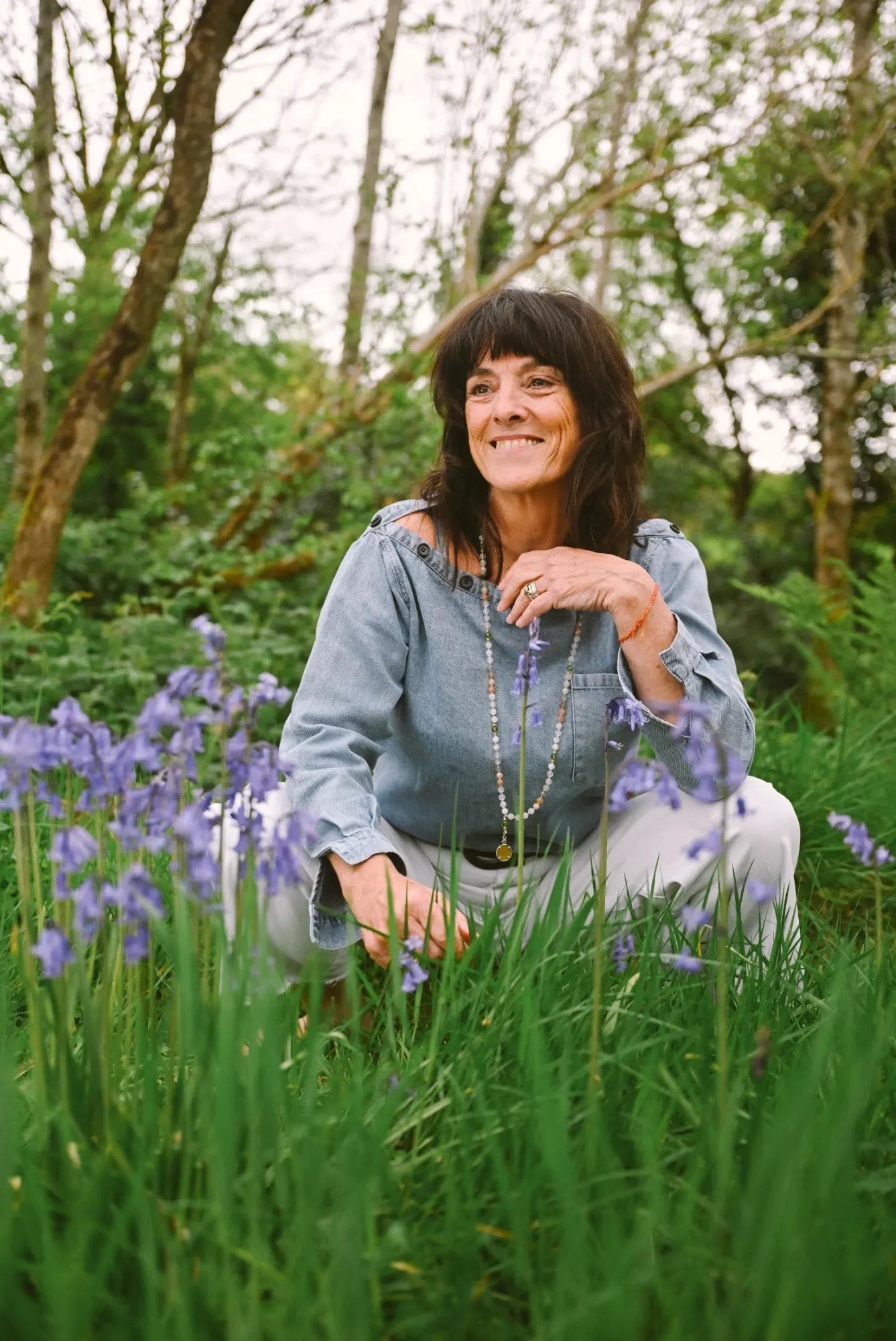 Catherine smiling among bluebells in a Kerry woodland