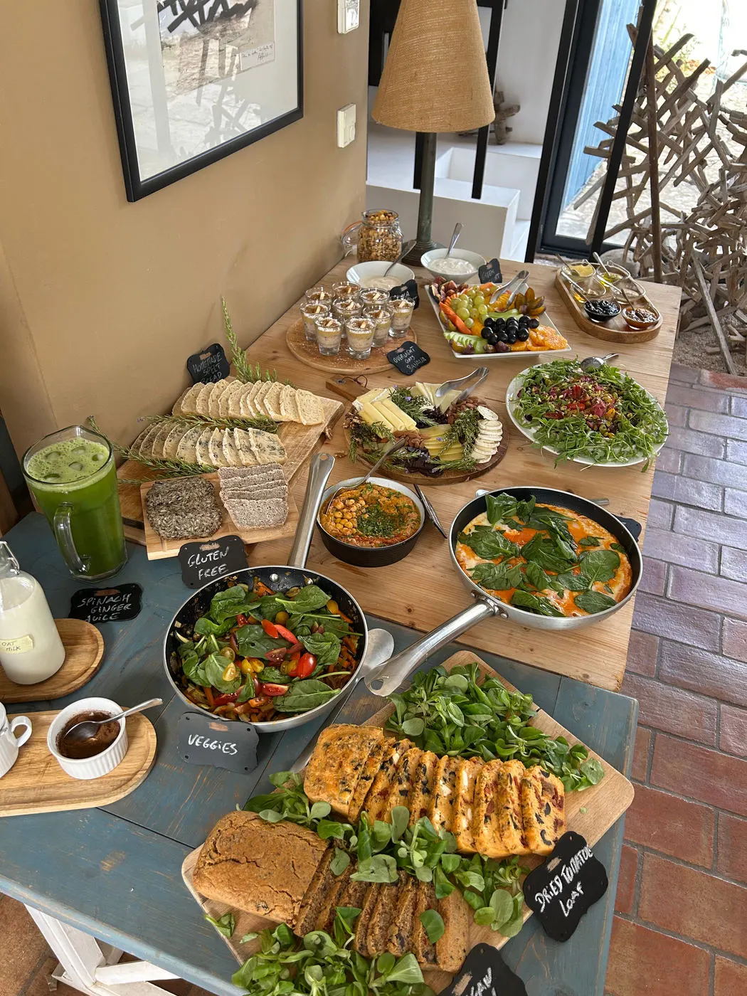 A long lunch table laid with salads, bread and dips
