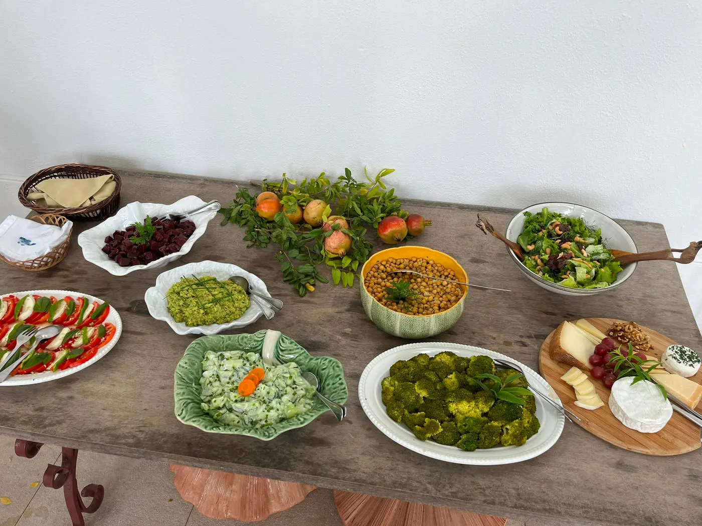A long table of fresh salads, dips, fruit and cheese