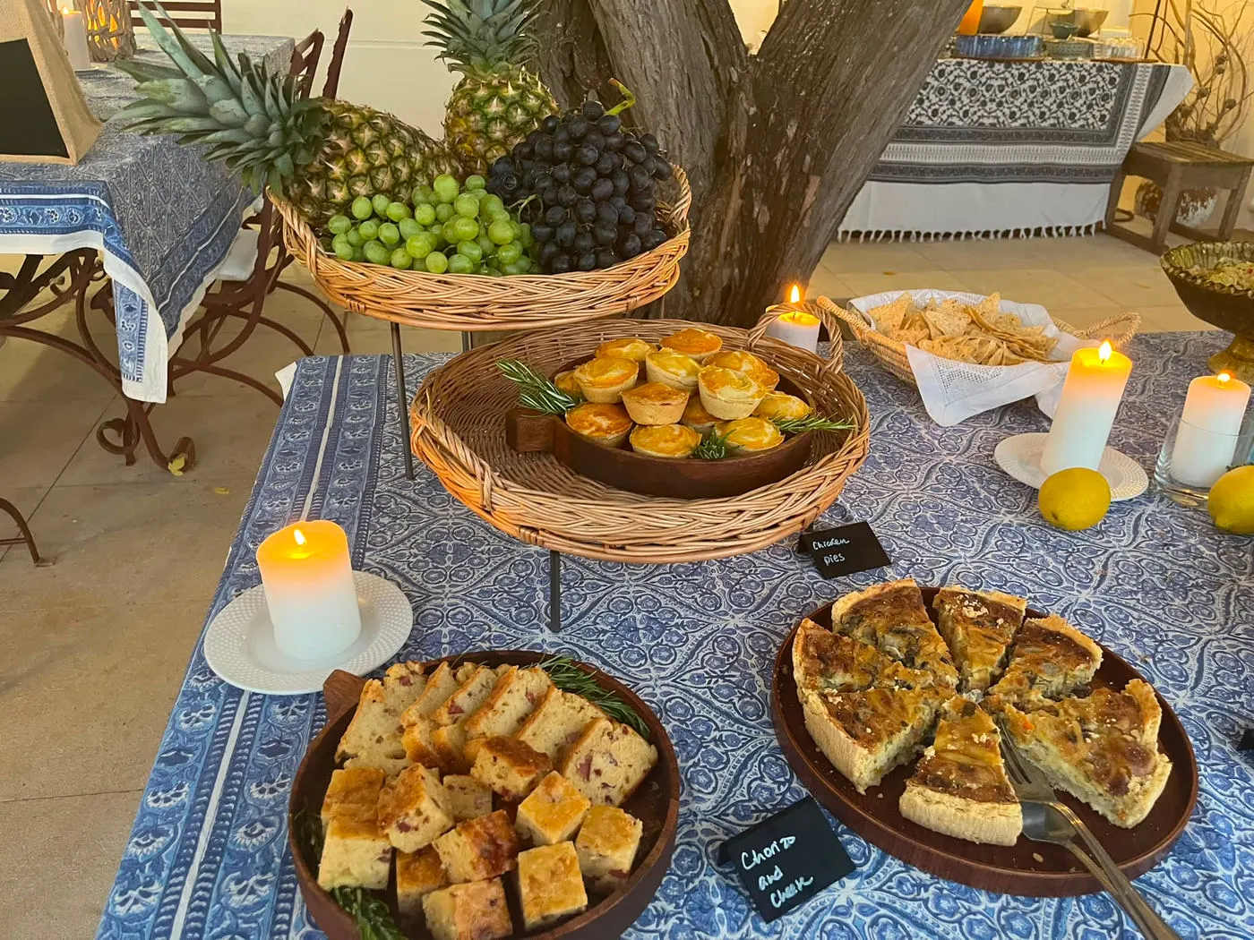 Home-made tarts, fruit and candles on a blue cloth