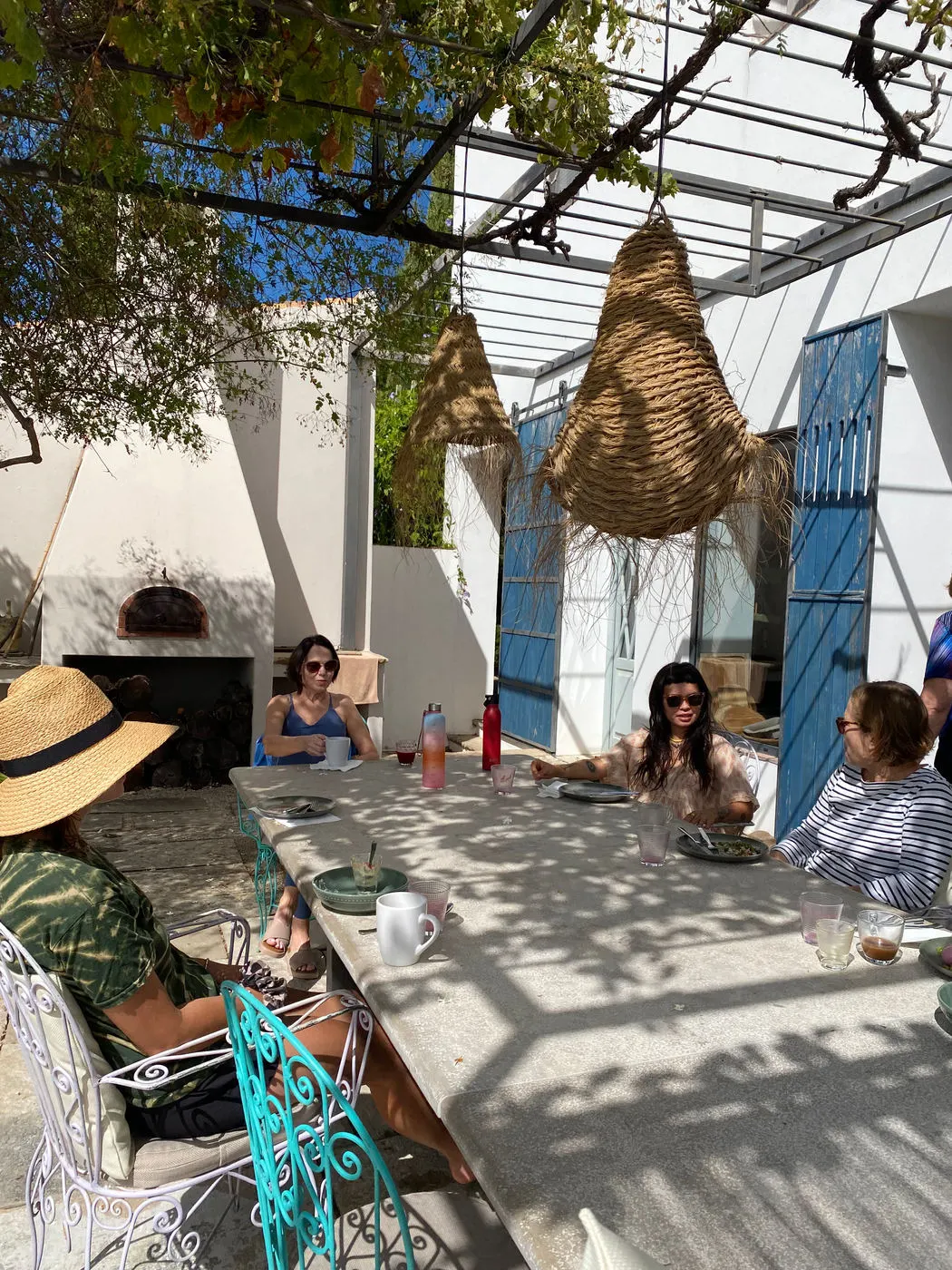 Guests sharing lunch at a long table under a pergola in Portugal