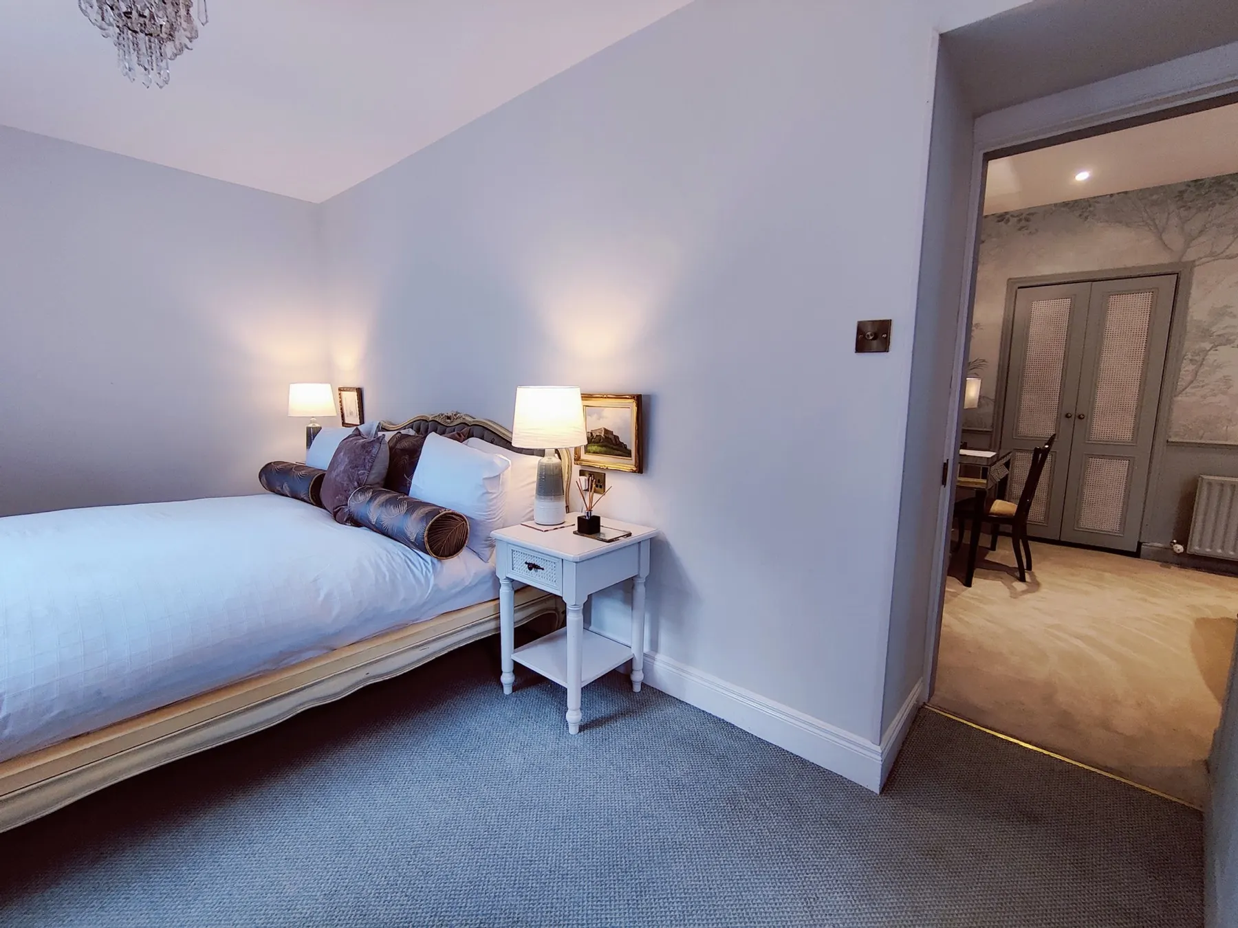 A cosy guest bedroom lit by bedside lamps