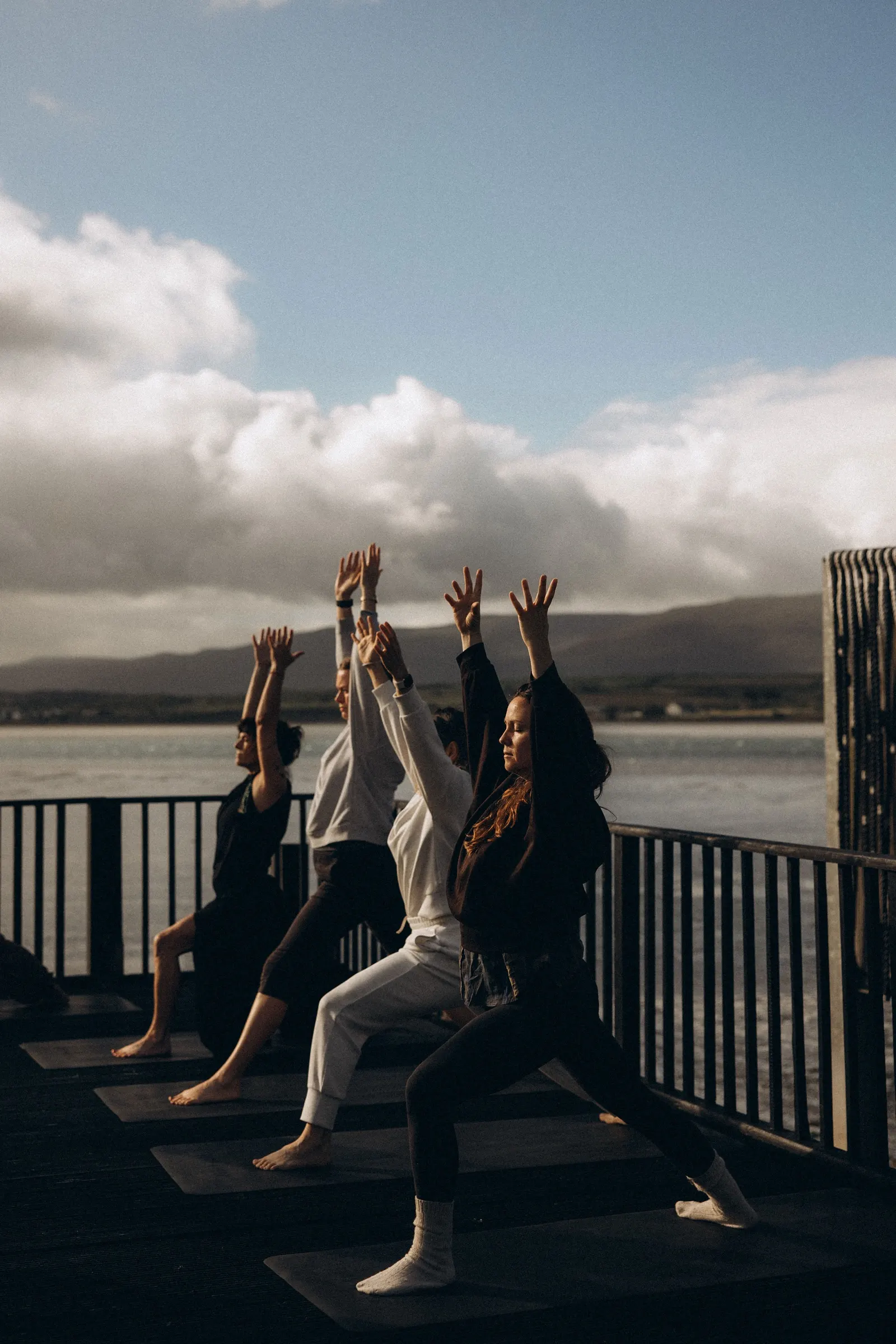 Guests reaching up together on the deck above the harbour