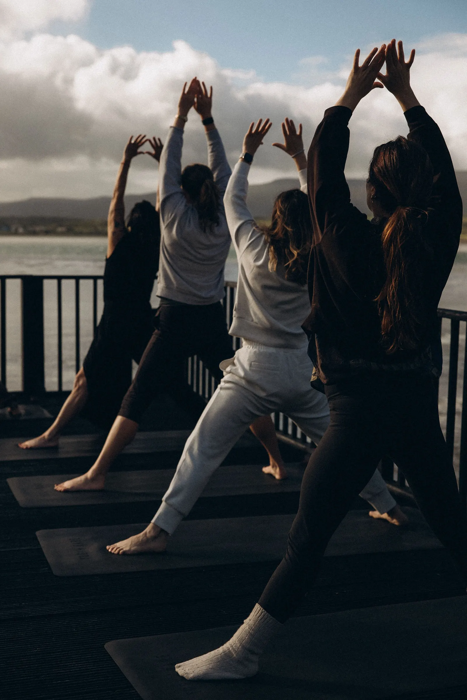 A group practising yoga together on the deck above Barrow Harbour