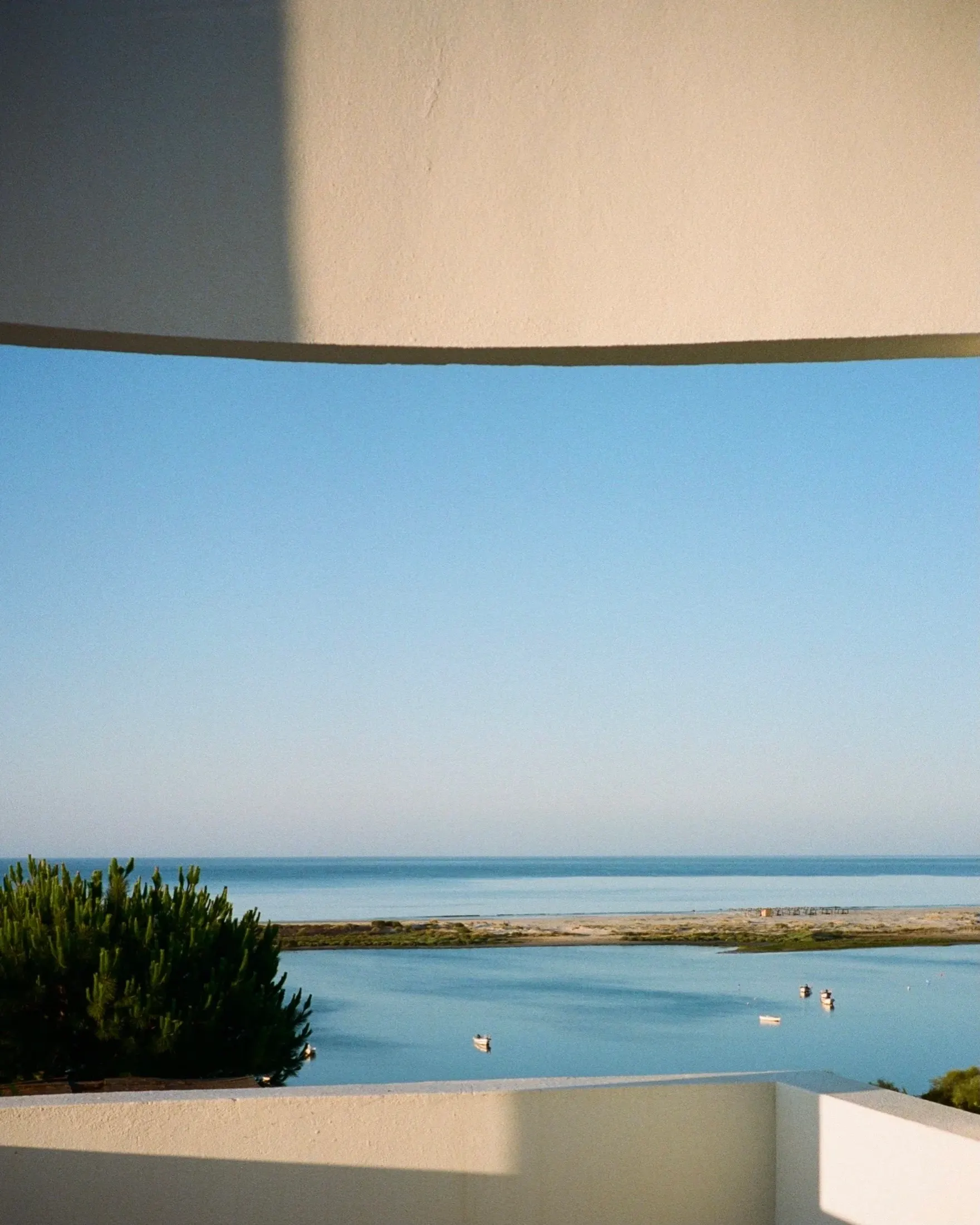 The lagoon and the sea framed by the curve of a white wall