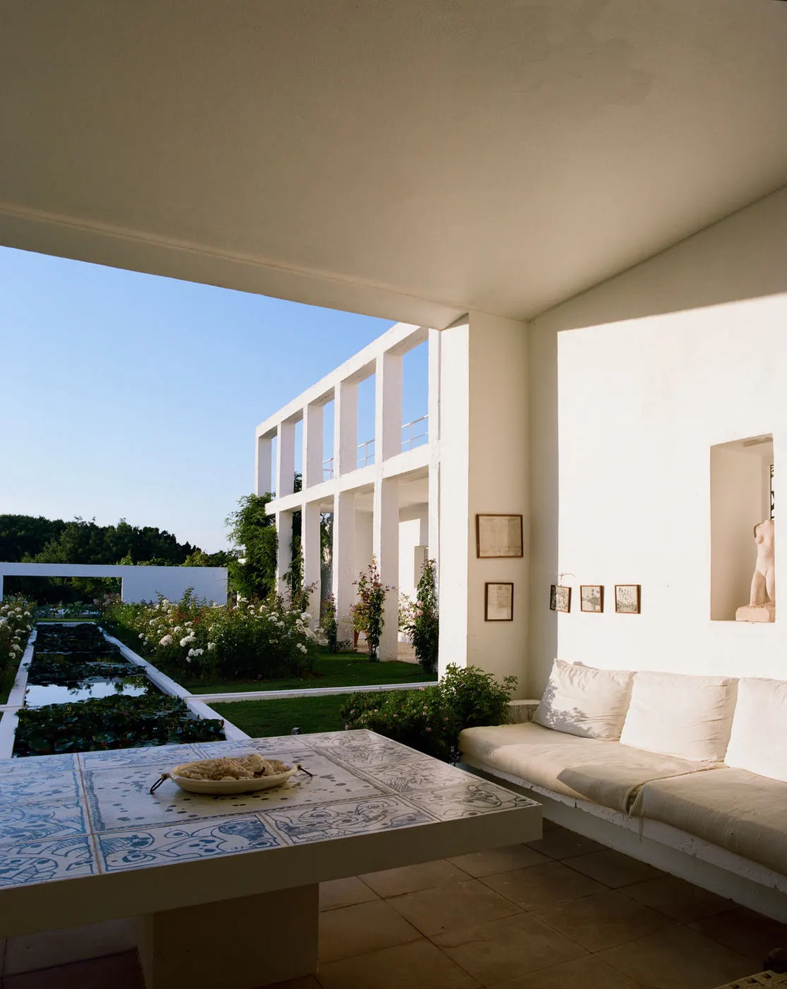 A shaded sitting area looking across the gardens to the house